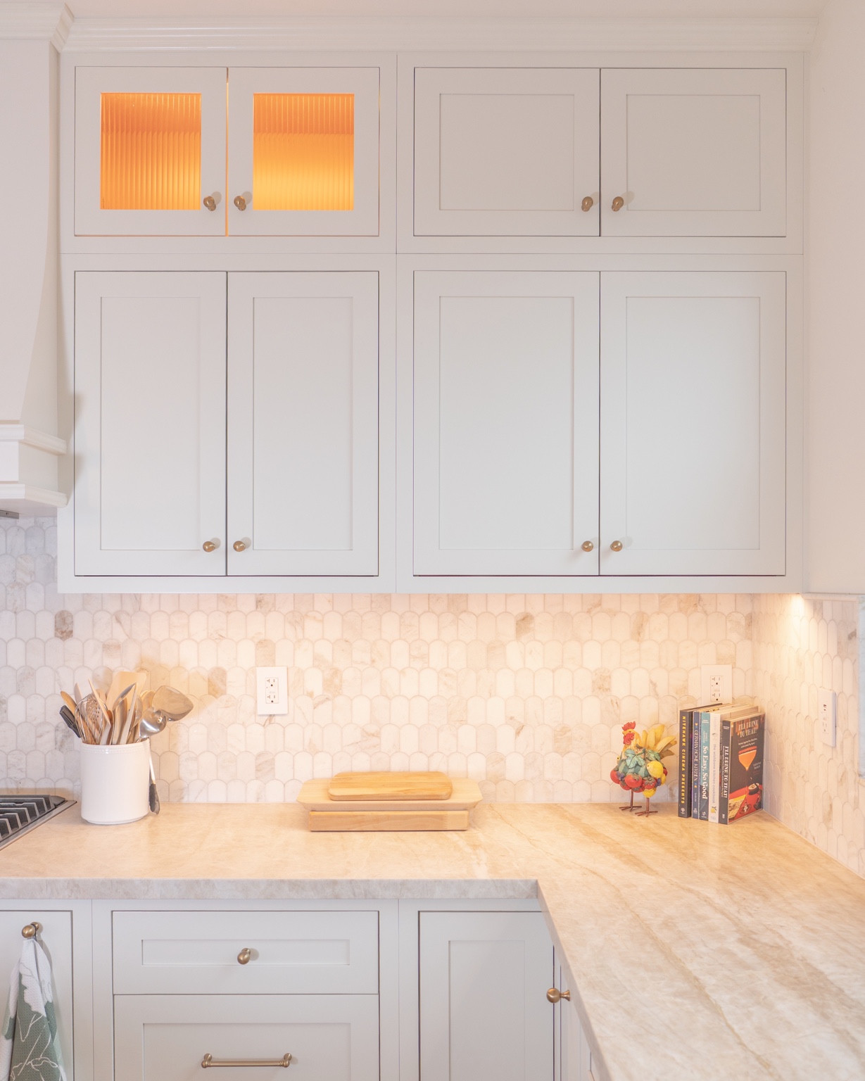 Cabinetry, natural stone and warm lighting